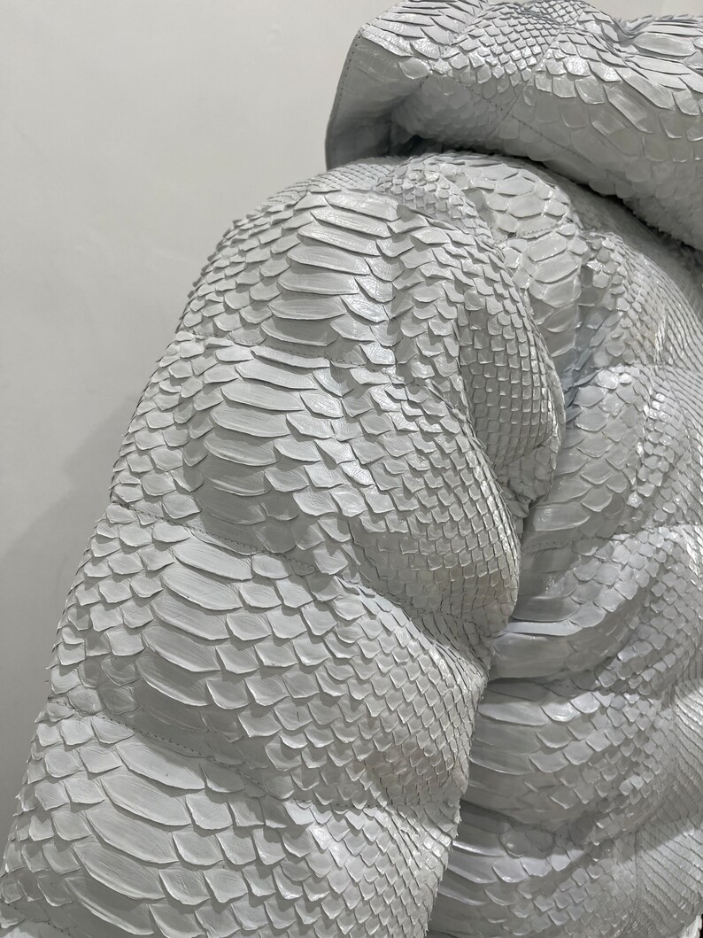 May include: White snakeskin jacket with a hood. The jacket is made from soft, supple leather and has a unique, textured pattern.