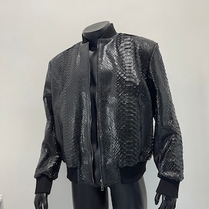 May include: A black leather bomber jacket with a snakeskin pattern.