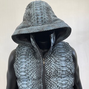May include: A hooded vest made of blue snakeskin with a zipper closure.