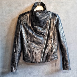 May include: A black leather jacket with a zipper closure and a snakeskin pattern.