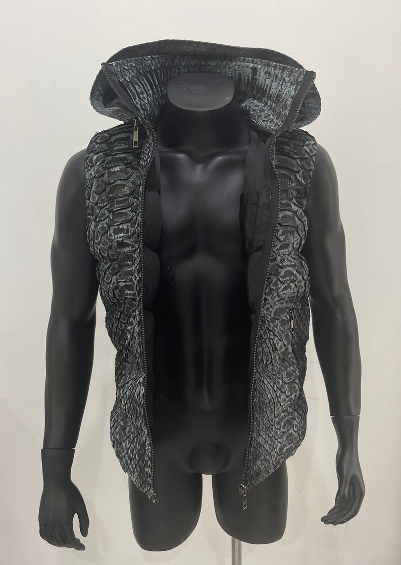 May include: A black sleeveless jacket with a zip fastening and a hood. The jacket has a snakeskin pattern.