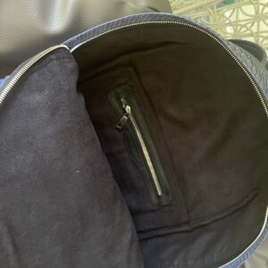 K&ouml;nnte beinhalten: Ein blauer Rucksack mit einer Rei&szlig;verschlusstasche im Inneren. Der Rucksack ist aus einem strukturierten Material gefertigt.