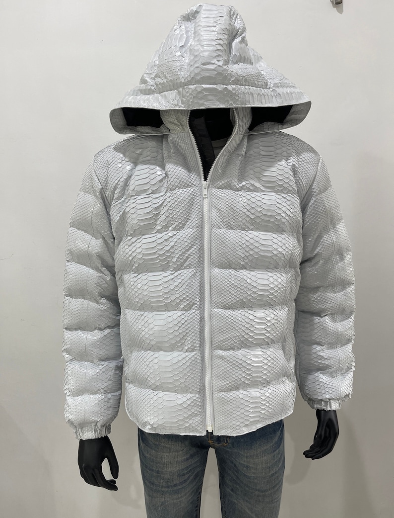 May include: A white puffer jacket made of snakeskin with a zip fastening and a hood.