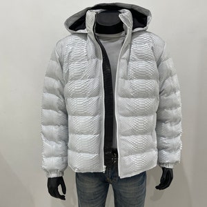 May include: White puffer jacket with a snakeskin pattern. The jacket has a hood and a zip closure.