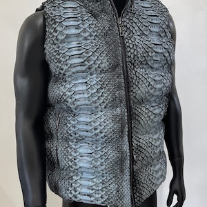 May include: A gray snakeskin vest with a zipper closure. The vest has a stand-up collar and a quilted lining.