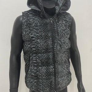 May include: A sleeveless hooded vest with a black and grey snakeskin pattern. The vest has a zip closure and a stand-up collar.