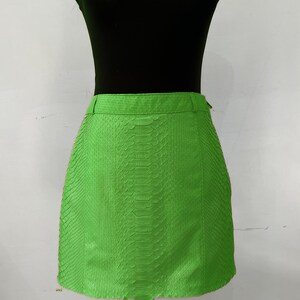 May include: A bright green mini skirt with a snakeskin pattern.