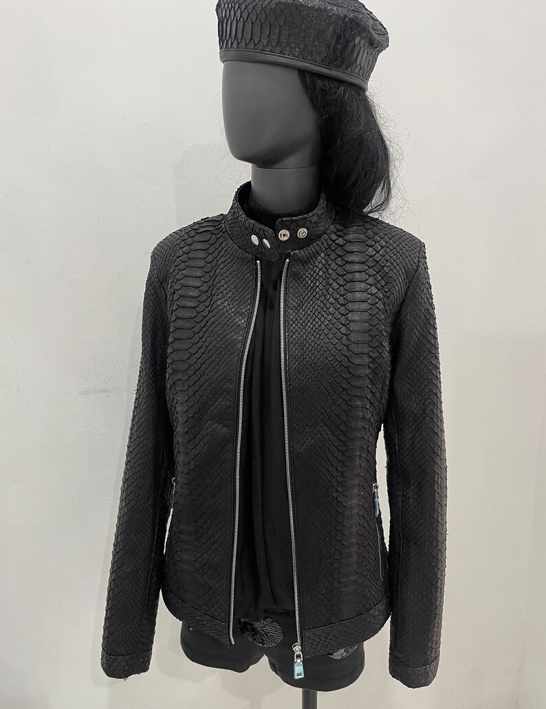 May include: Black leather jacket with a snakeskin pattern. The jacket has a zip fastening and a stand-up collar.