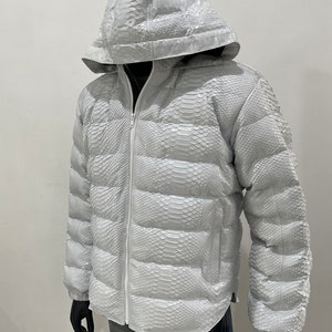May include: A white puffer jacket made of snakeskin with a zip fastening and a hood.