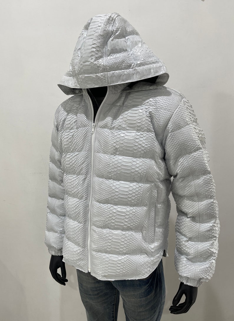 May include: A white puffer jacket made of snakeskin with a zip fastening and a hood.