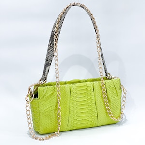 May include: A lime green snakeskin handbag with a gold chain strap. The bag has a flap closure and a structured shape.