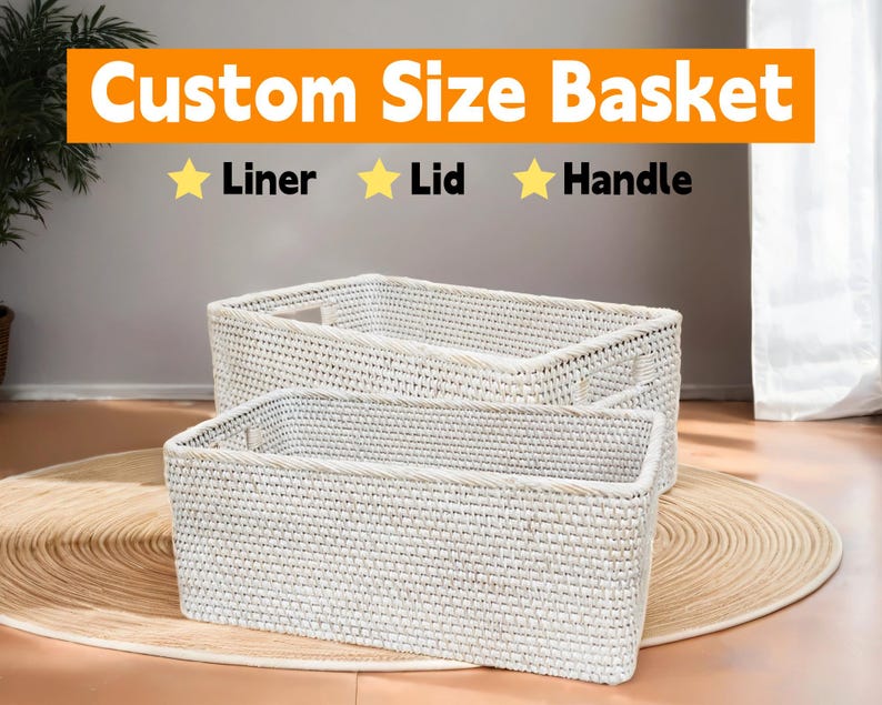 May include: Two white wicker baskets with a woven pattern. The baskets are stacked on top of each other. The top basket has a handle on each side. The bottom basket has a handle on each side. The baskets are on a light brown surface. Custom Size Basket, Liner, Lid, Handle.
