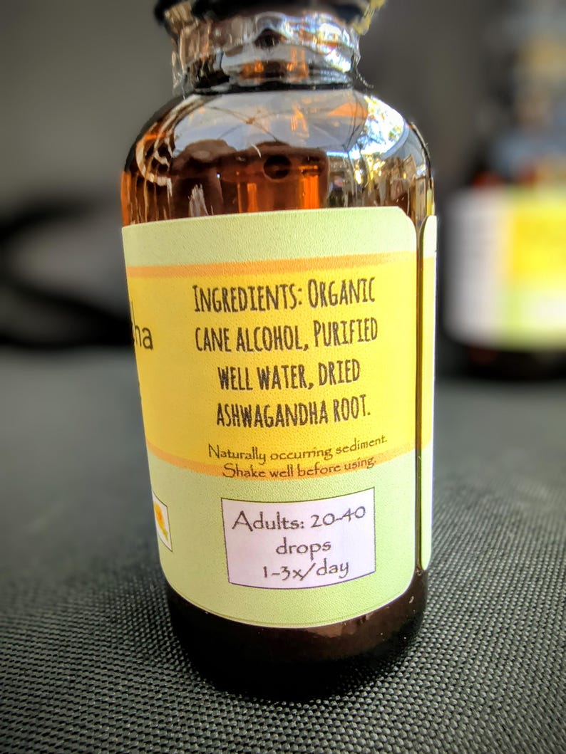 Puede incluir: Una peque&ntilde;a botella de vidrio marr&oacute;n con una etiqueta amarilla. La etiqueta enumera los ingredientes: Alcohol de ca&ntilde;a org&aacute;nico, agua purificada, ra&iacute;z de Ashwagandha seca. Instrucciones de dosificaci&oacute;n: 20-40 gotas, 1-3 veces/d&iacute;a.