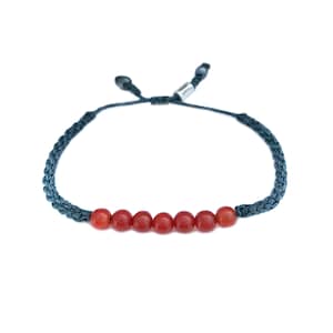 Puede incluir: Pulsera trenzada azul oscuro con siete cuentas redondas de color rojo anaranjado. La pulsera tiene un cierre corredizo ajustable. Las cuentas miden aproximadamente 0,8 cm de diámetro.