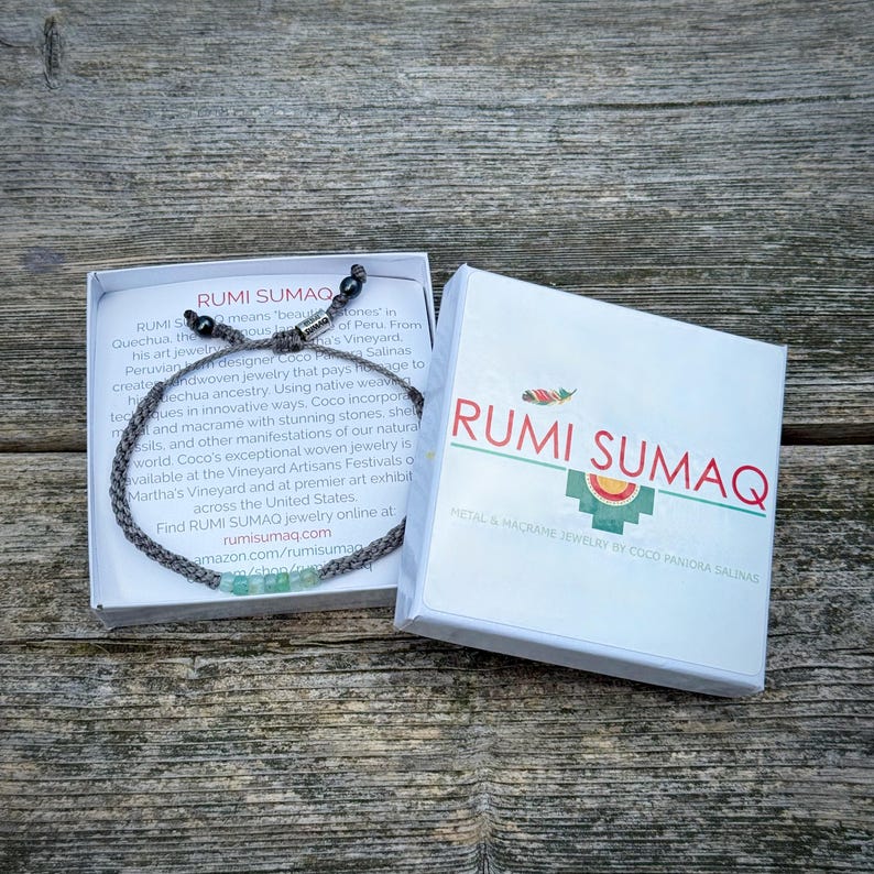 Custom handmade opal rope bracelet by Rumi Sumaq displayed in a branded gift box, perfect for men, women, and kids. Features blue green Peruvian Opal stones along hand-knotted fiber cords in personalized colors, finished with Hematite stone accents and a Rumi Sumaq logo bead. Ideal as a birthday, holiday, friendship, or meaningful gift, handcrafted by indigenous Quechua designer Coco Paniora Salinas on Martha’s Vineyard, combining artisan Peruvian heritage with wearable fiber art jewelry.