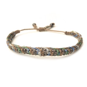 May include: A brown, green, and blue braided bracelet with adjustable sliding knots.