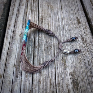 Bohemian statement bracelet in a bold, colorful macrame weave. This wide woven bracelet is a unique festival bracelet and perfect for boho styles. Its intricate knotted striped design makes it a standout piece of hippie jewelry for women and teen girls. Great as a teenage girl gift or boho gift for women who love handmade artisan jewelry. Comfortable for everyday wear or festival fashion. Rumi Sumaq jewelry, macrame jewelry for teen girls, unique woven bracelet.