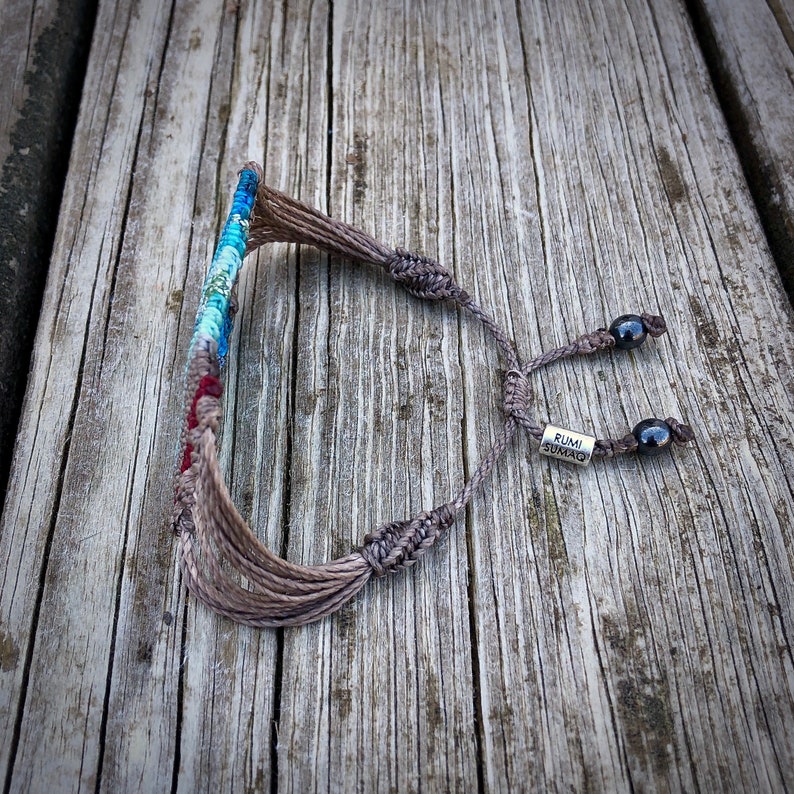 Bohemian statement bracelet in a bold, colorful macrame weave. This wide woven bracelet is a unique festival bracelet and perfect for boho styles. Its intricate knotted striped design makes it a standout piece of hippie jewelry for women and teen girls. Great as a teenage girl gift or boho gift for women who love handmade artisan jewelry. Comfortable for everyday wear or festival fashion. Rumi Sumaq jewelry, macrame jewelry for teen girls, unique woven bracelet.
