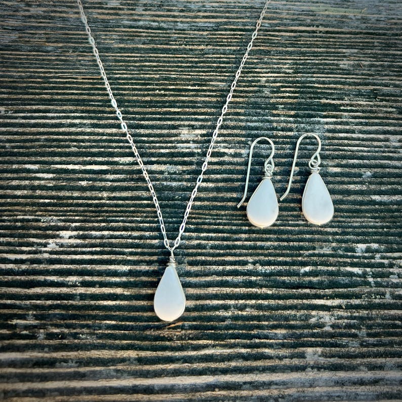 Handmade White Jasper Necklace & Earrings Set This handmade white jasper necklace & earrings set is crafted by Quechua jewelry designer Coco Paniora Salinas in his Rumi Sumaq art jewelry studio on Marthas Vineyard. The healing crystal jewelry set features a teardrop white jasper pendant necklace and matching white stone teardrop earrings available in sterling silver or 14k gold fill. White jasper is a spiritual stone known for clarity, peace and emotional healing making it a unique gift for her.
