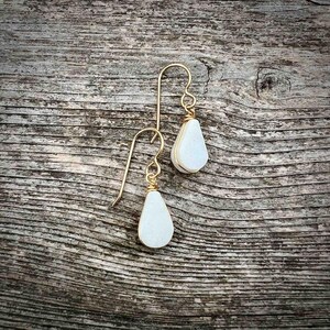 Elegant teardrop earrings handcrafted with genuine white jasper gemstones, these dangle earrings are designed for those who love boho jewelry sets with spiritual meaning. The lightweight stones are suspended from gold fill or sterling silver French ear wires making them a unique gift for her. Designed by Quechua artist Coco Paniora Salinas these earrings embody craftsmanship and energy healing. The white teardrop stone earrings come packaged ready for gifting in a beautiful RumiSumaq gift box.