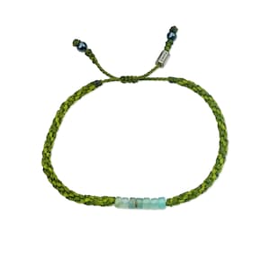 Hand-knotted Andean Opal bracelet in two-tone green fibers crafted by Indigenous Quechua artist Coco of Rumi Sumaq on Marthas Vineyard. This custom Andean Opal stone bracelet features seven genuine Peruvian Andean Opals accented with Hematite beads and a silver-toned logo bead. The calming green hues and natural opal energy promote balance, peace and creativity, making it an ideal handmade gift for men, women or kids celebrating October birthdays or anniversaries. Authentic Andean Opals bracelet