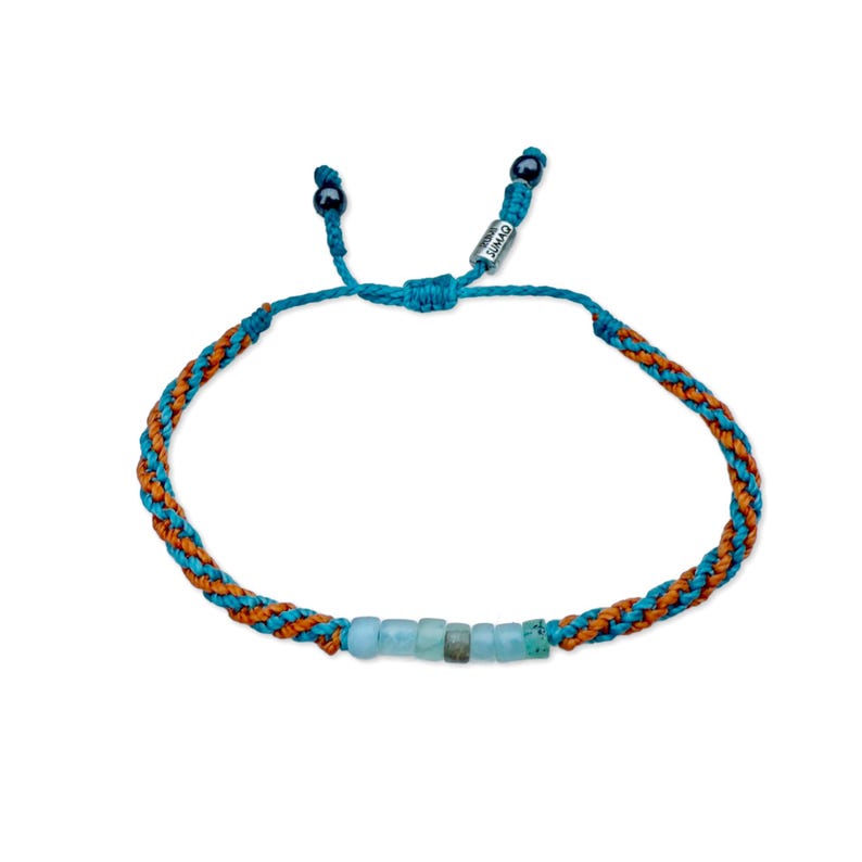 Rumi Sumaq custom Peruvian Opal bracelet shown with two custom fiber colors, blending personalized color choices for a unique unisex style. Designed and hand-knotted by Indigenous Quechua jewelry designer Coco and handmade on Martha’s Vineyard, each bracelet features seven natural Peruvian Opal stones, Hematite accents, and an adjustable drawstring for men, women, or kids. A perfect October birthstone and 24th anniversary gift that celebrates intention, balance, and artisanal craftsmanship.