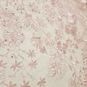 May include: Pink floral lace fabric with delicate embroidery and small, sparkling beads.