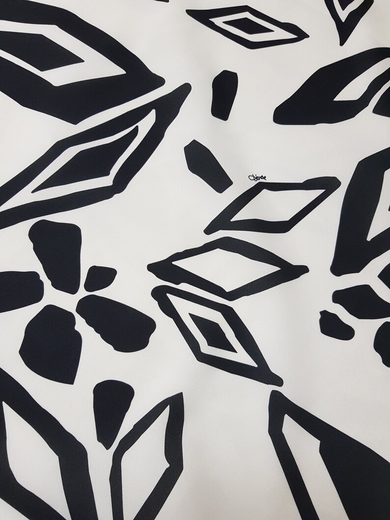 Puede incluir: Patr&oacute;n geom&eacute;trico en blanco y negro sobre fondo blanco. El patr&oacute;n presenta diamantes, cuadrados y formas abstractas.