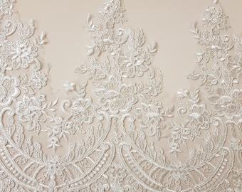 May include: White lace trim with a floral design. The lace has a scalloped edge and is perfect for adding a touch of elegance to any project.