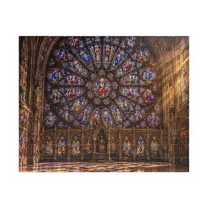 Peut inclure: Un puzzle représentant une grande rosace en vitrail circulaire à l'intérieur d'une cathédrale. Le verre complexe présente des teintes vives de bleu, rouge et jaune, avec de la lumière traversant pour projeter des reflets colorés au sol.