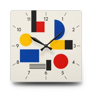 Puede incluir: Un reloj de pared cuadrado con esfera blanca, marcadores de hora negros y números del 1 al 12. El centro muestra una composición geométrica de un círculo amarillo, un rectángulo azul, un círculo rojo y varias formas negras, azules y rojas.