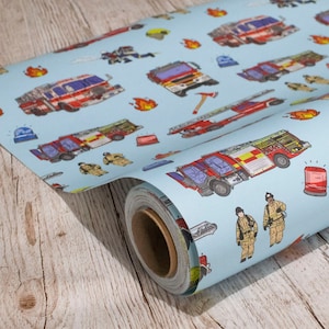 May include: A roll of blue wrapping paper with a fire engine theme. The paper features red fire engines, firefighters, axes, and flames on a light blue background.