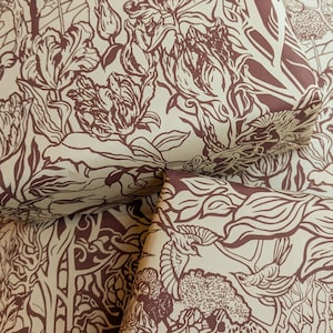 May include: A close-up of brown and cream wrapping paper with a floral pattern. The pattern features stylised flowers, leaves, and vines.