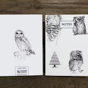 May include: Two white cards with black ink illustrations of owls. The card on the left features a single owl perched on a branch. The card on the right features three owls, a tree, and the word "NOTES". The card on the left has the text "Luxury Owls Cuttle Prints Hand-finished in England".