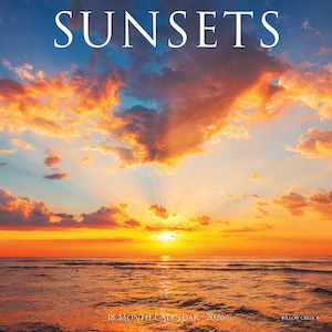 May include: A calendar titled "SUNSETS" features a vibrant sunset over the ocean. The sky is filled with orange, yellow, and blue hues, with the text "18 MONTH CALENDAR - 2026" at the bottom. The Willow Creek brand is also visible.