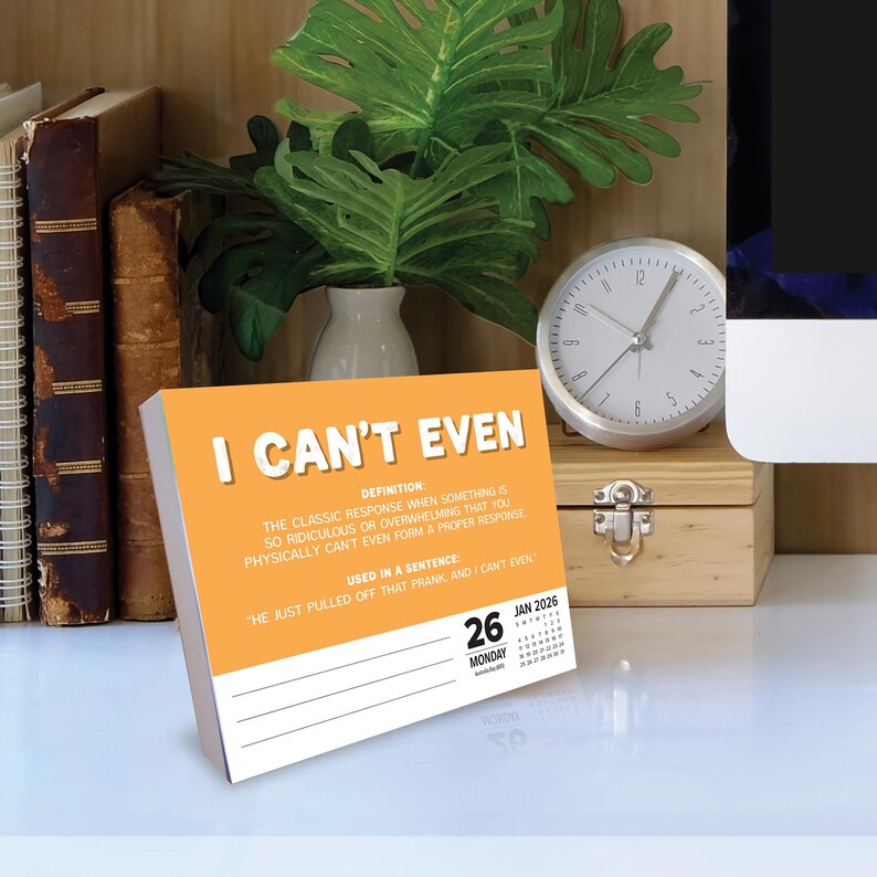 May include: An orange desk calendar with the phrase "I Can't Even" in white text. The calendar includes a definition and example sentence. A clock and books are in the background.