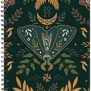 May include: A spiral-bound planner with a dark green cover featuring a central moth illustration, a crescent moon, and the text 20 27. The design includes symmetrical botanical patterns with leaves and ferns in shades of tan, brown, and white.