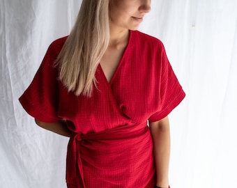 May include: A red wrap dress with short sleeves and a tie at the waist.