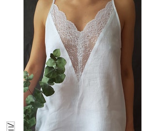 Peut inclure: Top en lin blanc avec un empiècement en dentelle en forme de V. La dentelle est blanche et délicate.