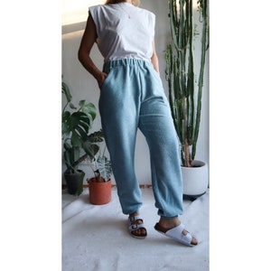 May include: A pair of light blue sweatpants with a relaxed fit. The sweatpants have a drawstring waistband and are made of a soft, comfortable fabric.