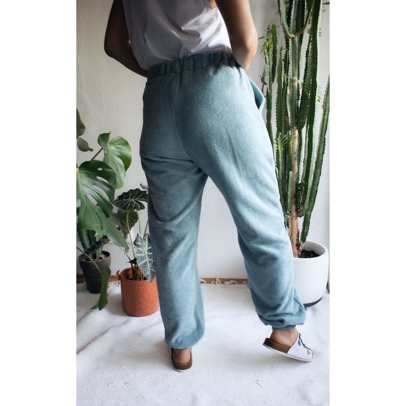 May include: A pair of light blue sweatpants with a drawstring waistband. The sweatpants are made of a soft, comfortable fabric.