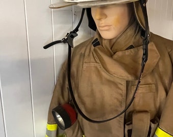 May include: A tan firefighter's uniform on a mannequin. The uniform includes a helmet with the text "UR NAME LEATHER FD" and a matching coat with reflective yellow stripes. A flashlight is attached to the coat.