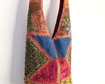 Puede incluir: Un bolso de hombro de patchwork colorido con una variedad de telas y bordados. El bolso está hecho de diferentes colores, incluyendo rojo, verde, azul, amarillo y naranja. El bolso tiene una correa larga y es perfecto para llevar los artículos esenciales del día a día.