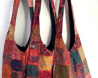 Puede incluir: Tres bolsos de mano de patchwork con correas largas. Los bolsos están hechos de telas de diferentes colores, incluyendo rojo, rosa, marrón y verde. Los bolsos tienen una variedad de diseños bordados y están decorados con borlas.