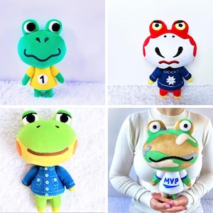 May include: Four plush frog toys in various outfits. One frog wears a yellow shirt with the number 1, another has a red and white head with a blue sweater, a third wears a blue denim jacket, and the last one has a camouflage head and a white shirt with "MVP".