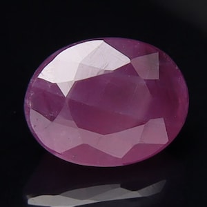 Może przedstawiać: Różowy owalny kamień szlachetny o szlifie fasetowym.