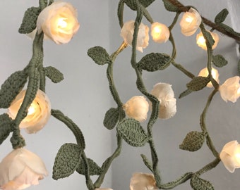 Lichterkette mit cremefarbenen Rosen an einer Blätter - Girlande