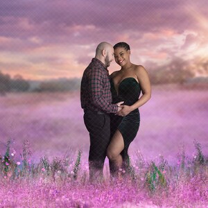 May include: A pregnant woman wearing a green velvet dress and a man in a checked shirt stand in a field of purple flowers. They are looking at each other and smiling.