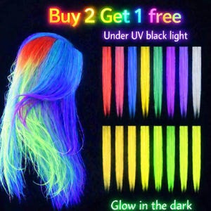 May include: A wig with rainbow colors and a collection of colorful hair extensions. The wig features red, orange, yellow, green, and blue hues. The hair extensions are in various neon colors. Text reads "Buy 2 Get 1 free" and "Glow in the dark."