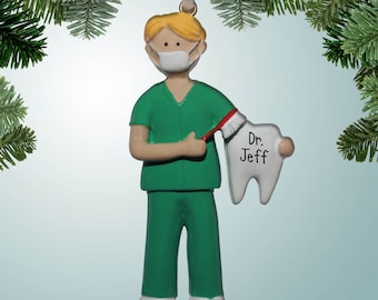 May include: Green and white Christmas ornament of a dentist holding a toothbrush and a large tooth with the name "Dr. Jeff" written on it.